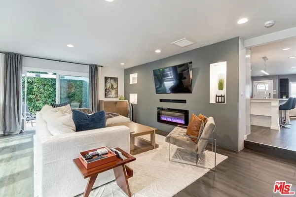 a living room with furniture a flat screen tv and a large window