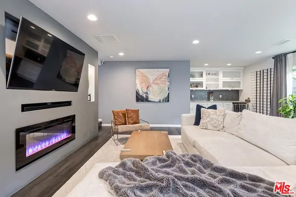 a living room with furniture a flat screen tv and a fireplace