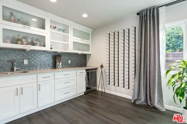 a kitchen with stainless steel appliances white cabinets and wooden floor