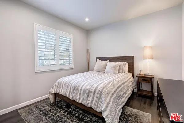 a bedroom with a bed lamp and a window
