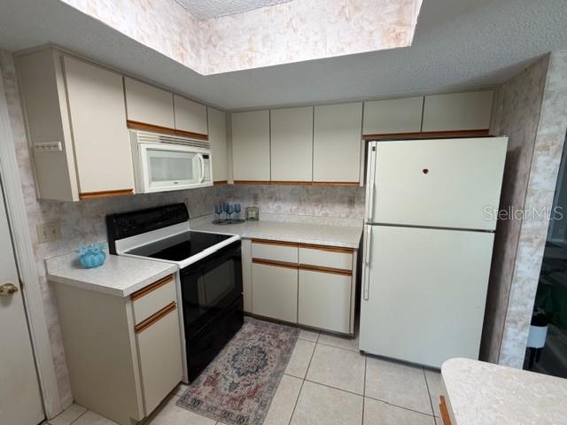 10740 Southwest 62nd Avenue Road Ocala, FL 34476 - Photo 6 of 19 a kitchen with a refrigerator sink stove and cabinets