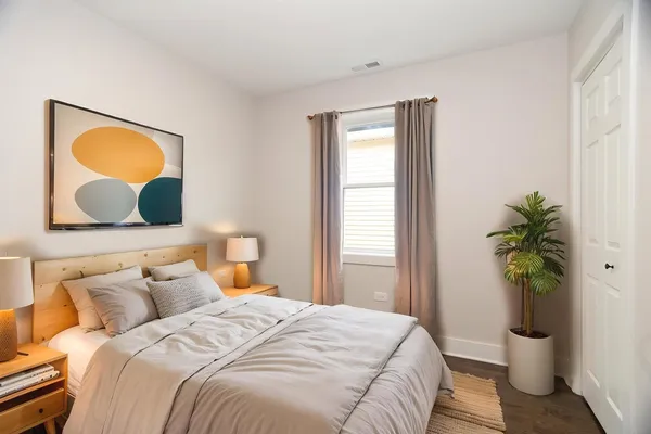 a bedroom with a bed and a potted plant