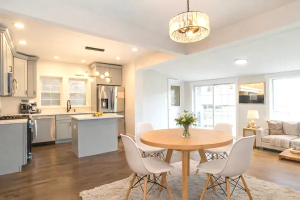 a dining room with wooden floor and stainless steel appliances