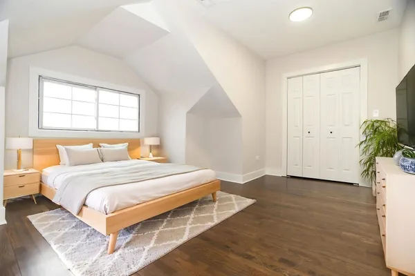 a bedroom with a bed and a potted plant
