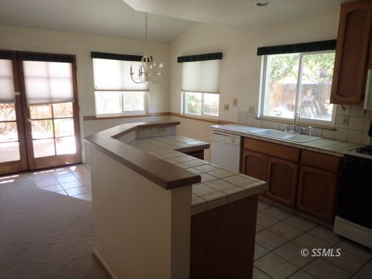 607 Plumblossom Court Ridgecrest, CA 93555 - Photo 4 of 28 a kitchen that has a sink a window and stainless steel appliances