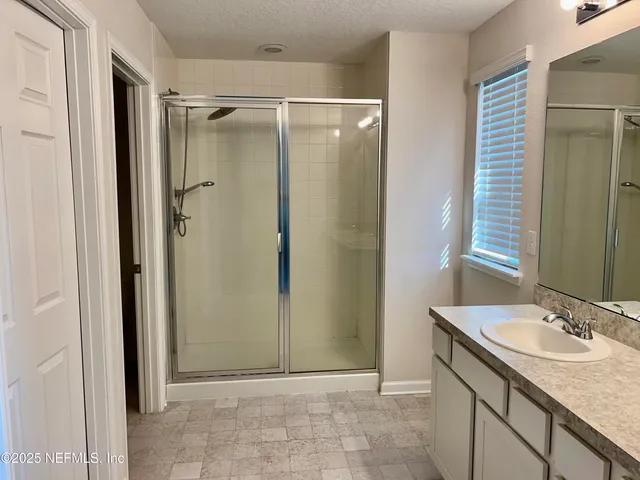a bathroom with a granite countertop shower sink and a mirror
