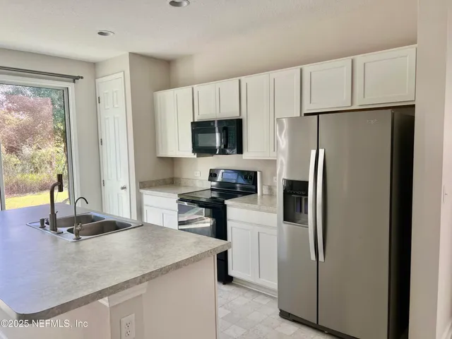 a kitchen with a refrigerator sink and stove