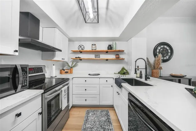 a kitchen with kitchen island a stove a sink and wooden cabinets
