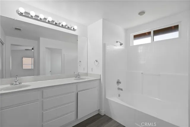 a bathroom with a double vanity sink and a mirror