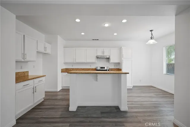 a kitchen with stainless steel appliances granite countertop a sink stove and cabinets
