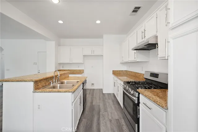 a kitchen with a stove and wooden floor