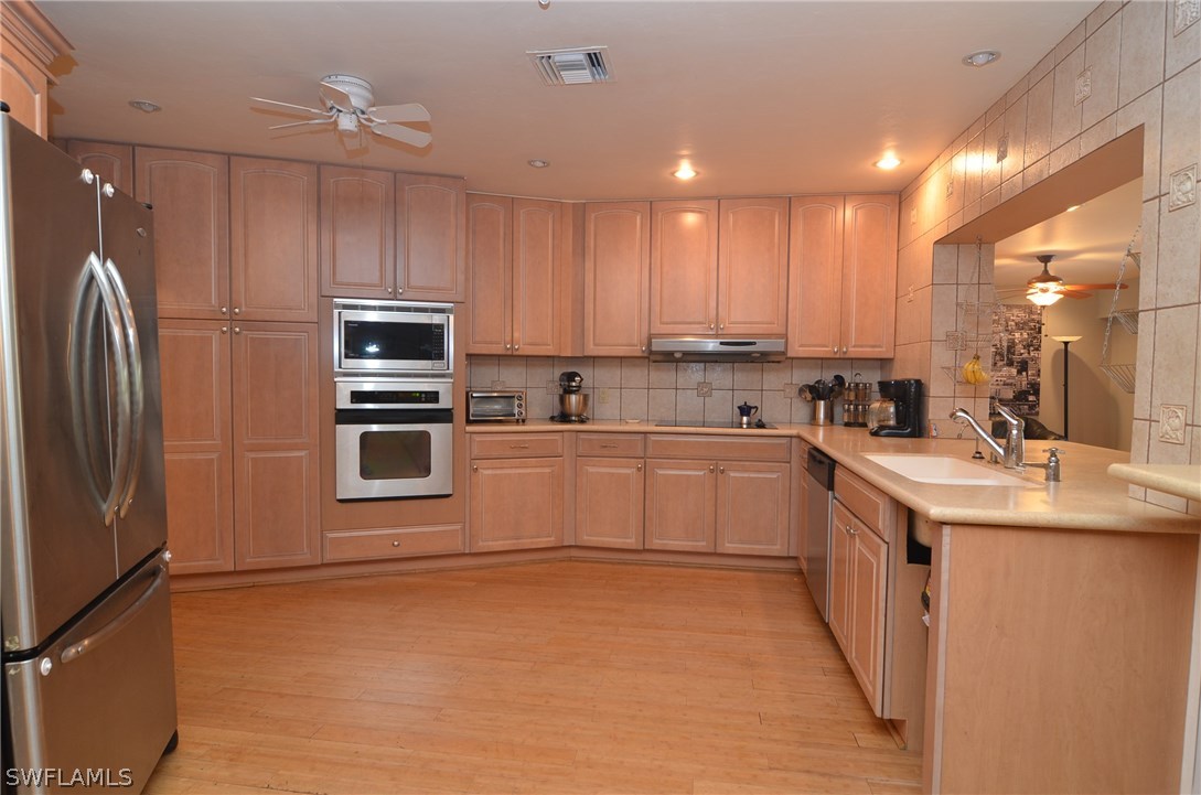 8312 Riviera Avenue Fort Myers, FL 33919 - Photo 11 of 24 a kitchen with a sink cabinets stainless steel appliances and a window