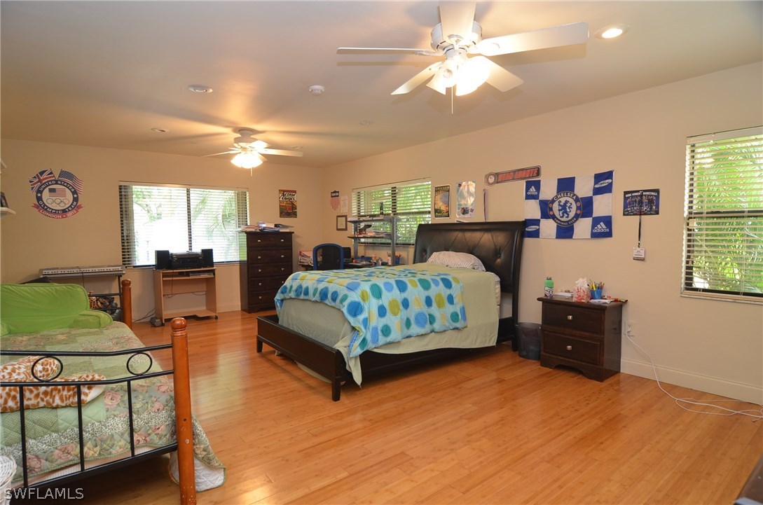 8312 Riviera Avenue Fort Myers, FL 33919 - Photo 19 of 24 a bedroom with a bed and a chandelier