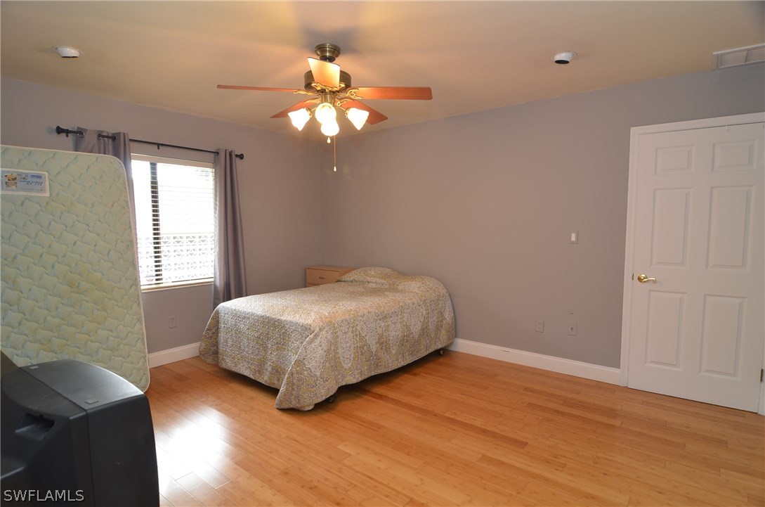 8312 Riviera Avenue Fort Myers, FL 33919 - Photo 20 of 24 a bedroom with a bed and a chandelier