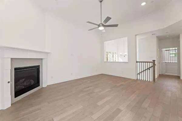 an empty room with windows and fireplace
