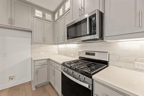 a kitchen with stainless steel appliances a stove microwave and cabinets