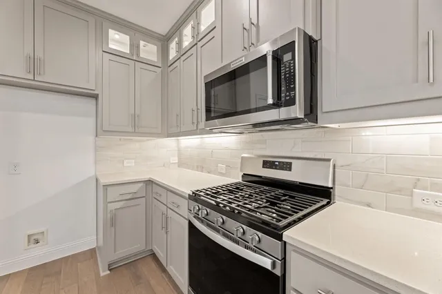 a kitchen with stainless steel appliances a stove microwave and cabinets