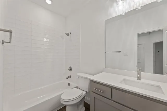 a bathroom with a granite countertop sink a toilet and shower