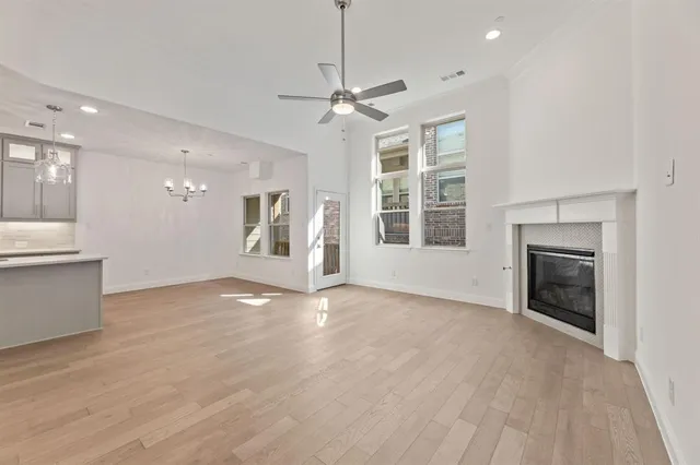 a view of an empty room with a window and kitchen view
