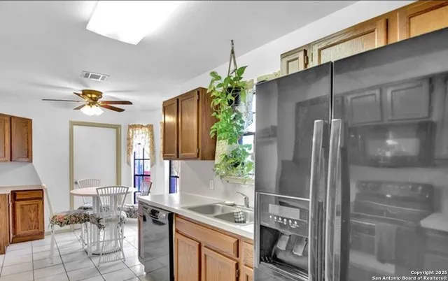 a kitchen with a refrigerator and chairs