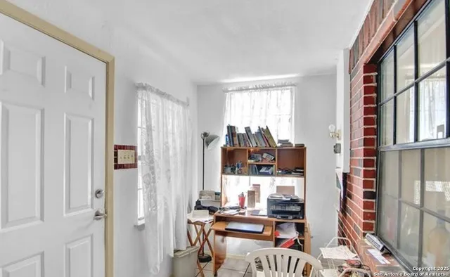 a work room with furniture a flat screen tv and a window