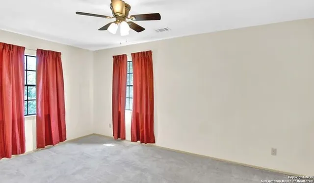 a view of a room with window and a ceiling fan