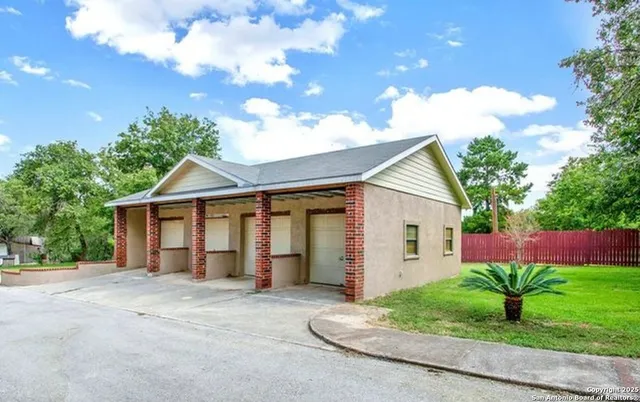 a view of a house with a yard and potted plants