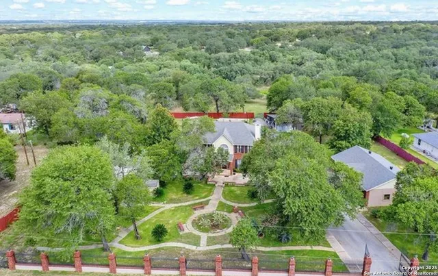 an aerial view of residential houses with outdoor space and trees