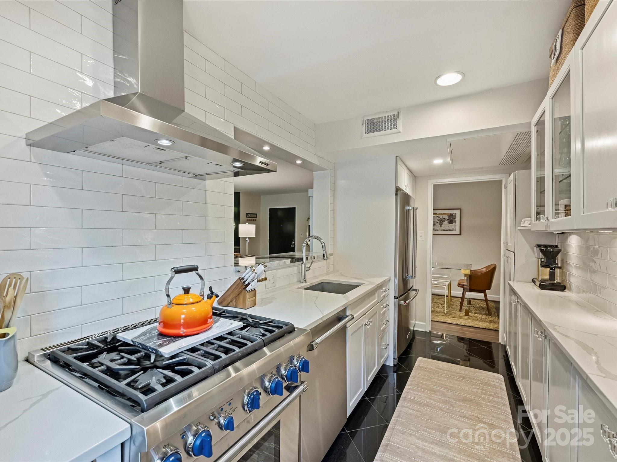 1300 Queens Road, Unit 202 Charlotte, NC 28207 - Photo 9 of 26 a kitchen with stainless steel appliances granite countertop a stove and a sink