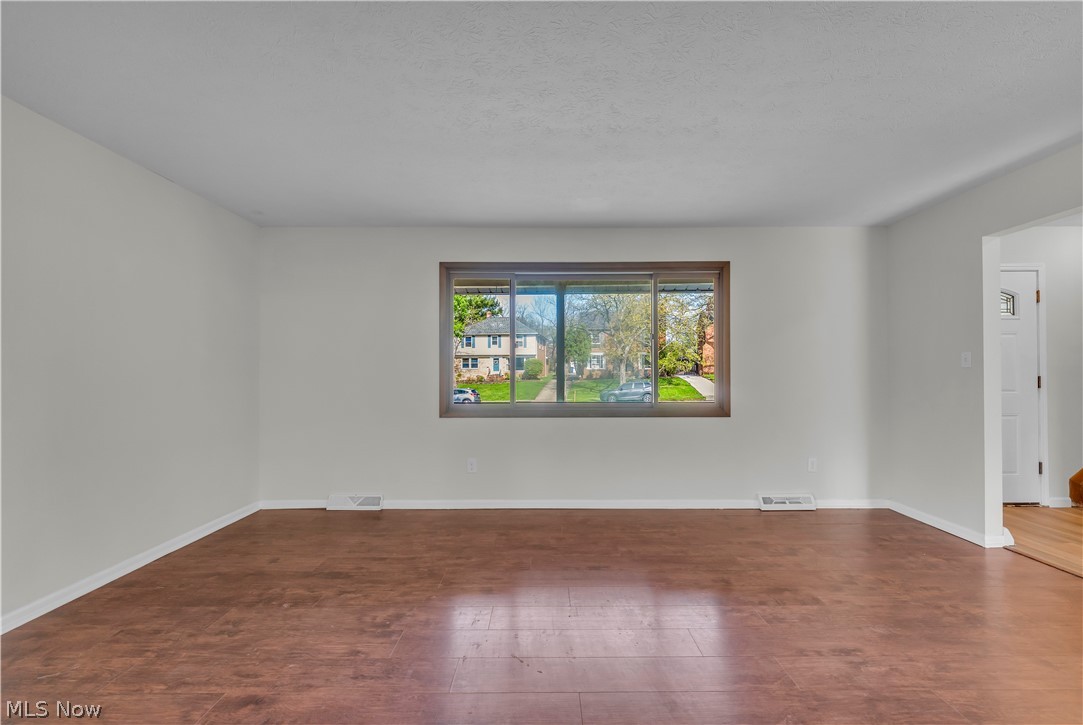 2540 Charney Road University Heights, OH 44118 - Photo 5 of 44 Bright interior space featuring wood-finish flooring, white walls, and a large window with a wood-trimmed frame
