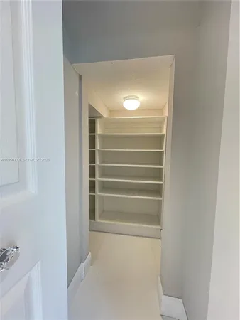 a view of an empty room with stairs and a window