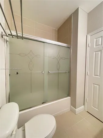 a walk in closet with wooden floor