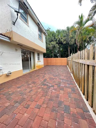 a view of an house with backyard and trees