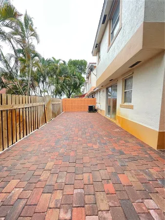 a view of backyard with large trees and wooden fence