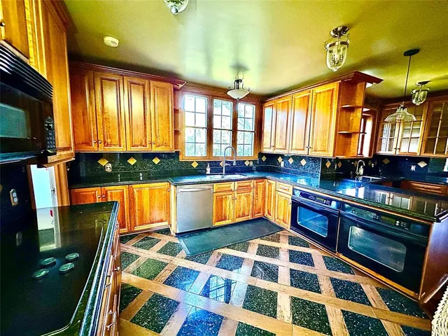 a kitchen with stainless steel appliances granite countertop a stove a sink and a microwave