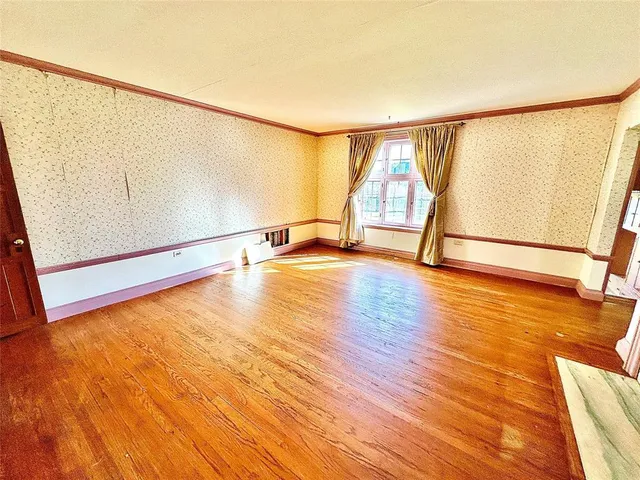 a view of a room with wooden floor and window