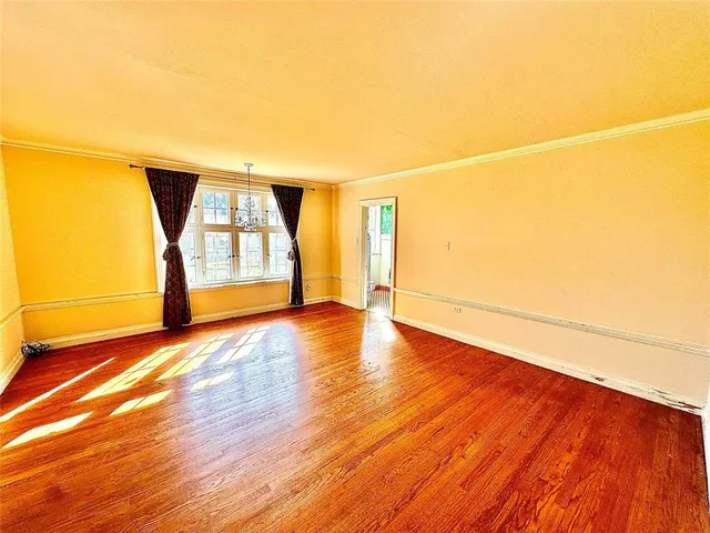 a view of empty room with wooden floor and fireplace