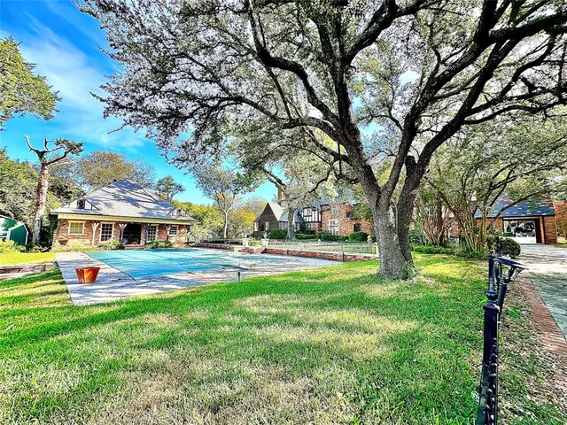 a view of yard with swimming pool and trees