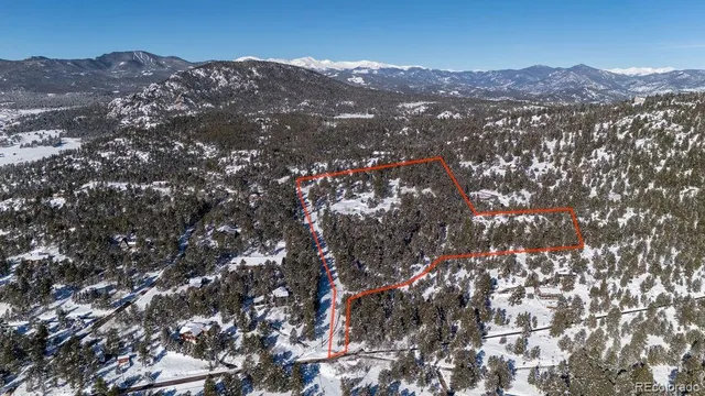 an aerial view of mountain and residential houses covered with trees