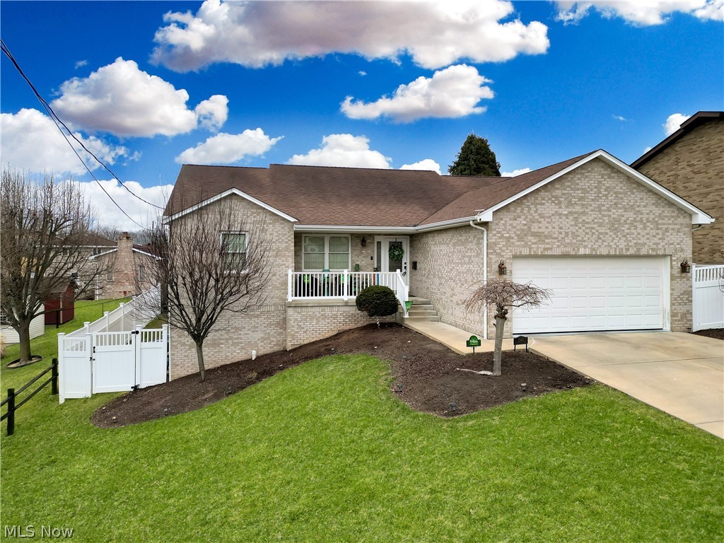 1343 Courtland Road Weirton, WV 26062 - Photo 1 of 50 Single story home featuring an attached garage, concrete driveway, brick siding, a porch, and roof with shingles