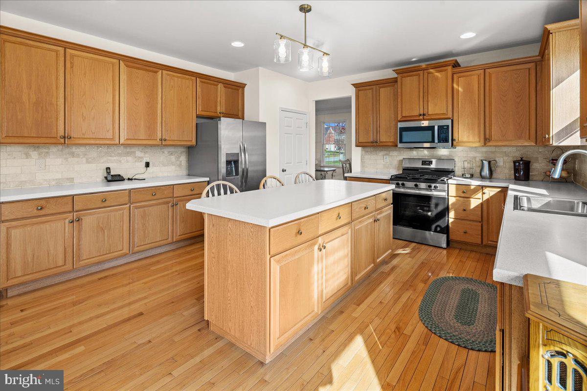 1 Gardengate Court Columbus, NJ 08022 - Photo 12 of 41 a kitchen with stainless steel appliances granite countertop a stove top oven a sink dishwasher and a refrigerator with wooden floor