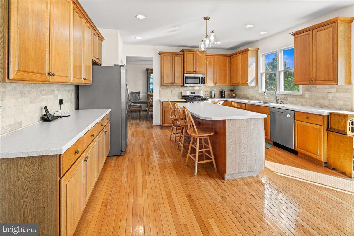 1 Gardengate Court Columbus, NJ 08022 - Photo 13 of 41 a kitchen with stainless steel appliances a microwave a stove a sink dishwasher and a refrigerator with wooden floor
