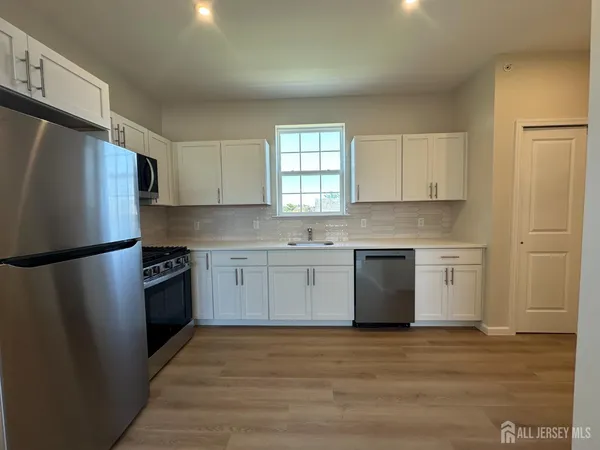 a kitchen with a refrigerator sink and cabinets