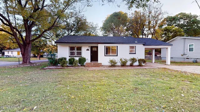 a view of a house with backyard and sitting area