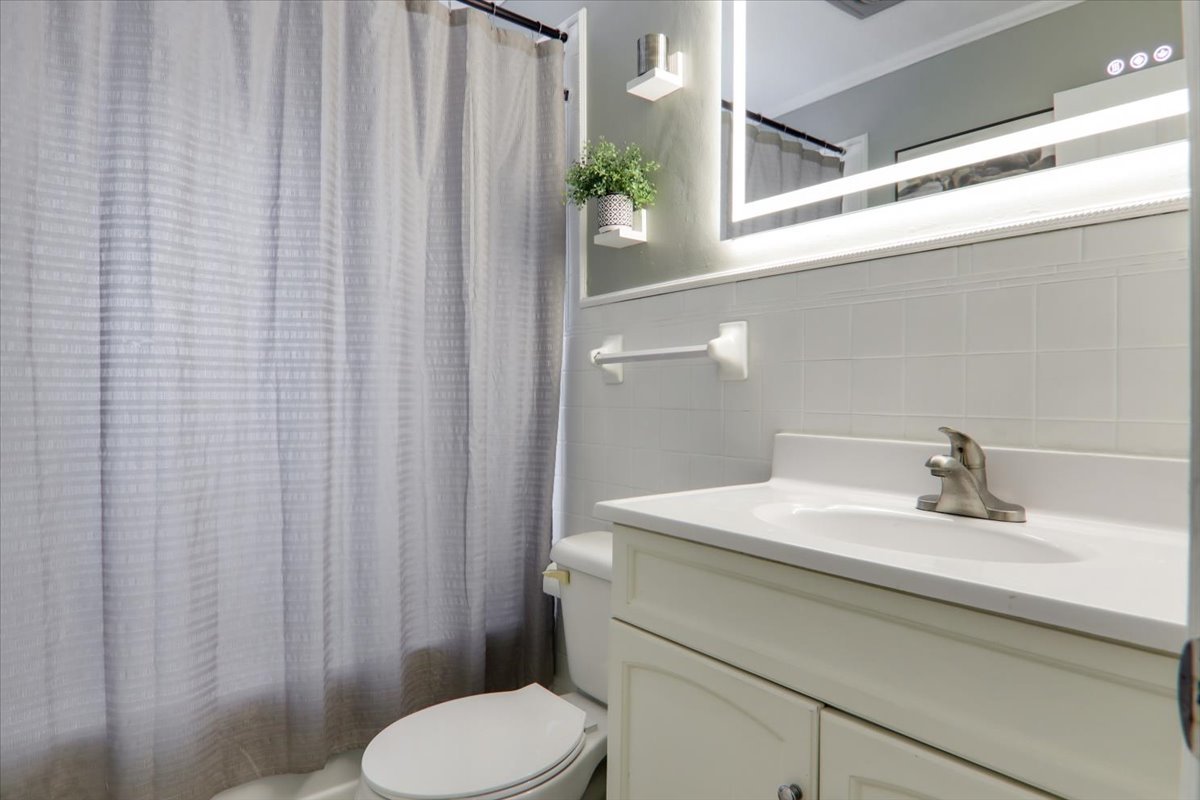 1812 Shady Crest Street Decatur, IL 62521 - Photo 11 of 16 a bathroom with a sink a toilet and shower curtain