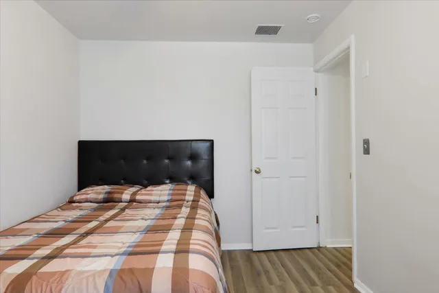 a bedroom with a bed and wooden floor