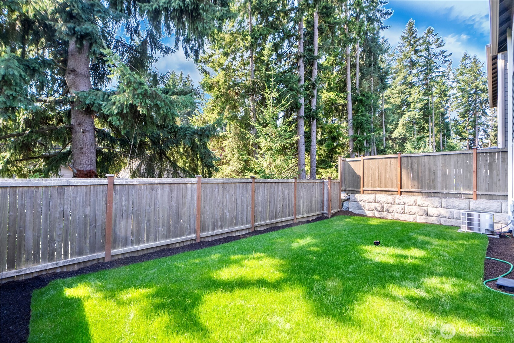 1130 199th Street Southeast Bothell, WA 98012 - Photo 31 of 33 a view of a backyard with a fence and a large tree