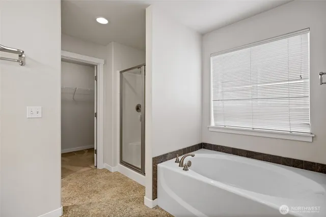 a bathroom with a tub a window and a shower