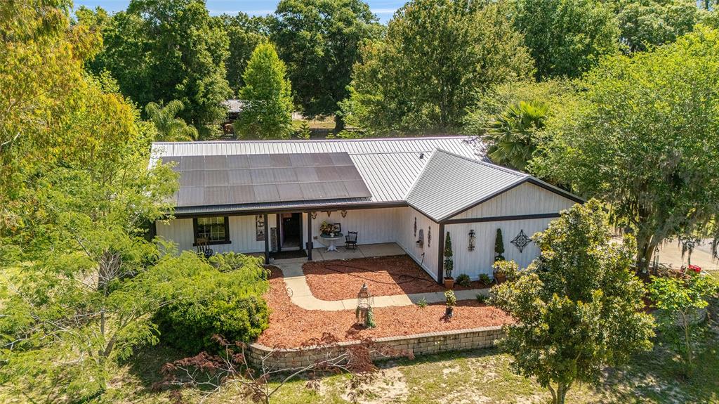 aerial view of a house with swimming pool next to a yard