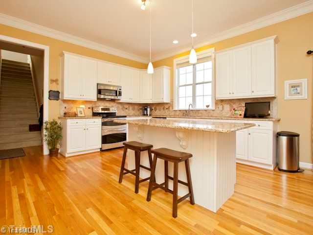 7839 Wilson Farm Road Summerfield, NC 27358 - Photo 5 of 16 Kitchen. Great updated kitchen with granite counter tops, tile backsplash, stainless steel appliances, island, large pantry, and updated light fixtures